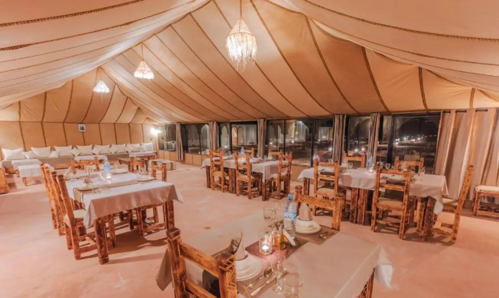 Inside the dining tent with tables and handmade lamps