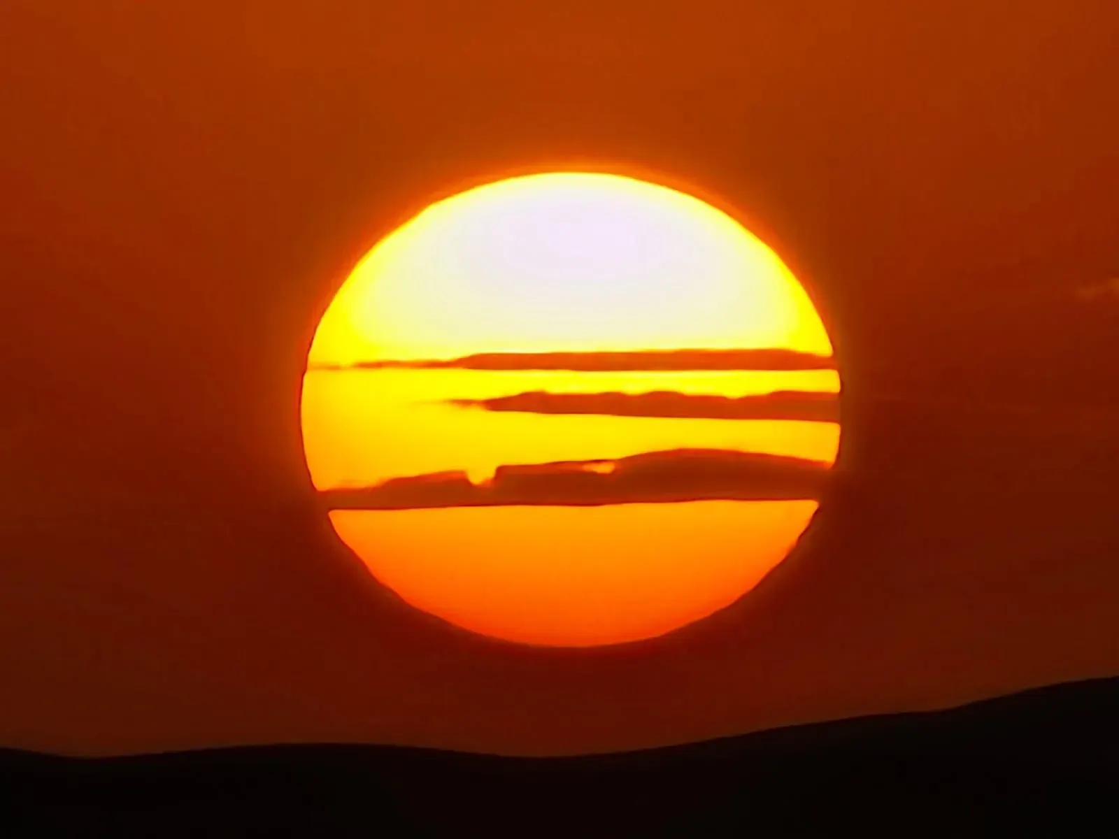 Huge sun setting over the desert horizon